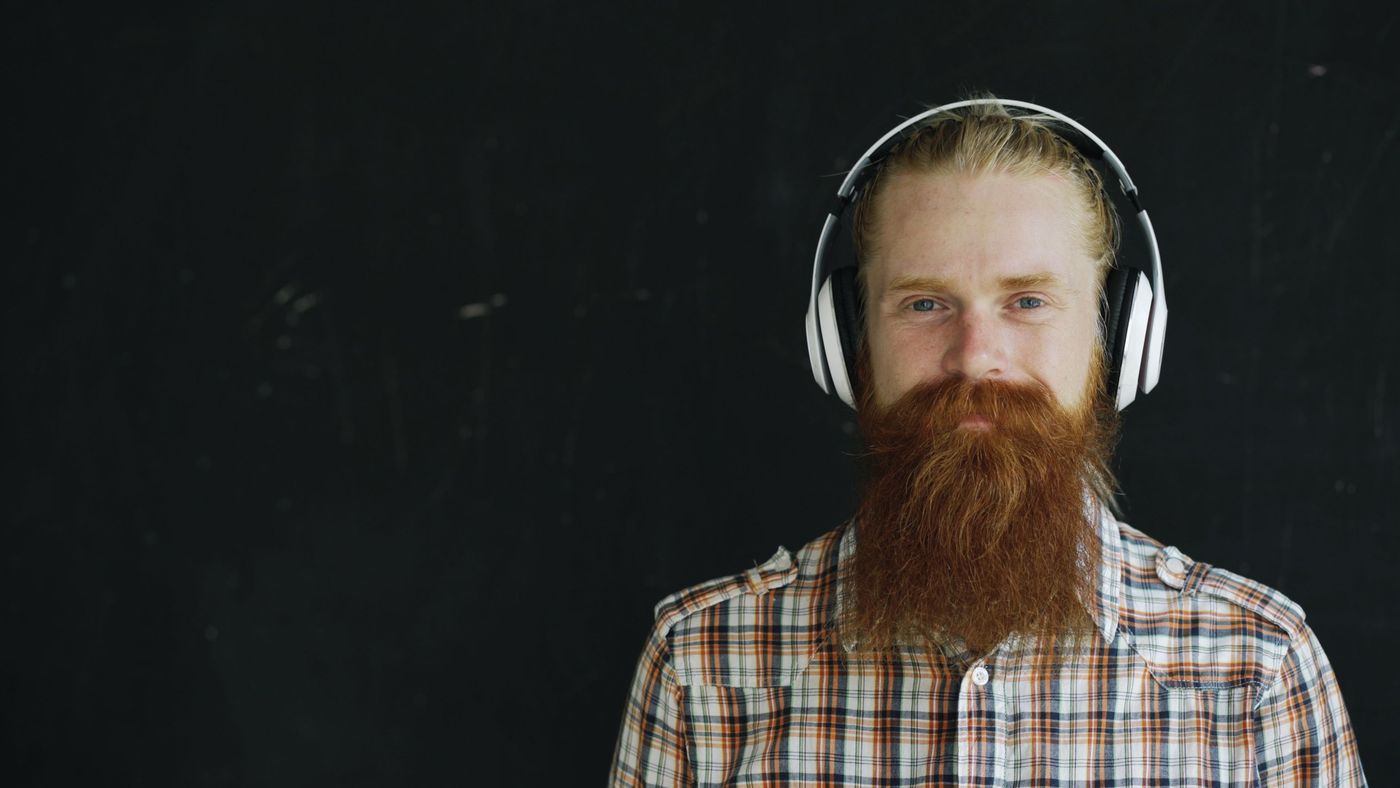 A bearded man in headphones looking into the camera