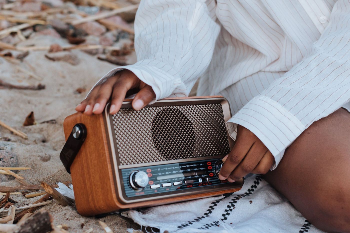 A vintage radio being tuned on a sunlit beach